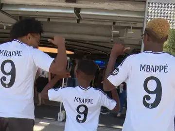 Aficionados madridistas posan con la camiseta de Mbappé