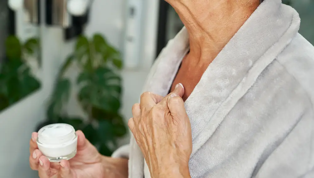 Mujer echándose crema en el cuerpo Mujer echándose crema en el cuerpo