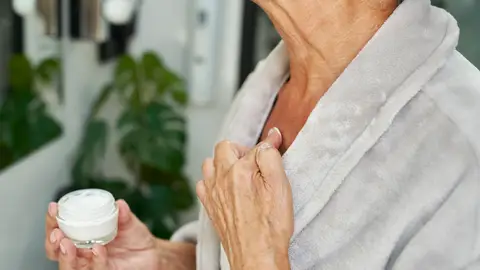 Mujer echándose crema en el cuerpo Mujer echándose crema en el cuerpo
