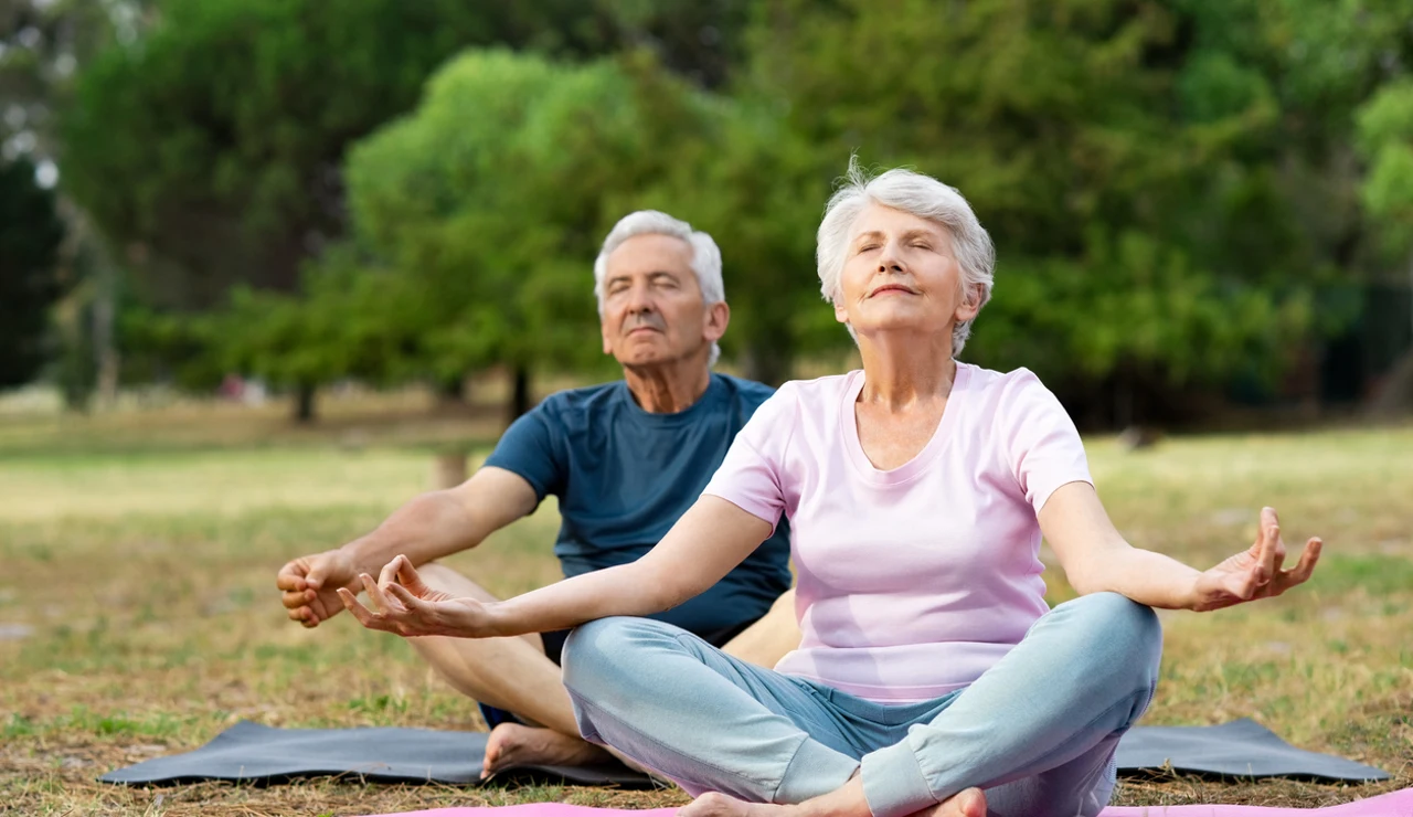 Dos personas mayores haciendo yoga