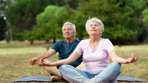 Dos personas mayores haciendo yoga
