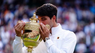 El tenista espa&ntilde;ol Carlos Alcaraz celebra con el trofeo tras la victoria sobre el serbio Novak Djokovic en su partido final de tenis masculino individual el d&iacute;a catorce del Campeonato de Wimbledon 2024 en el All England Lawn Tennis and Croquet Club.