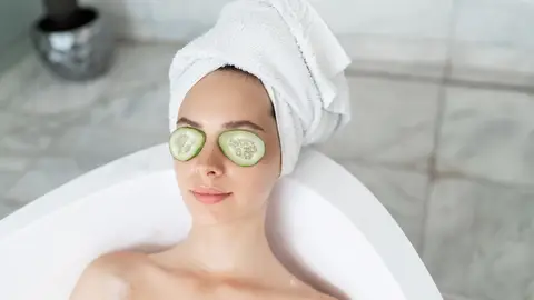 Mujer con rodajas de pepino Mujer con rodajas de pepino