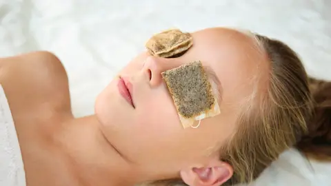 Una mujer con bolsas de té en los ojos Una mujer con bolsas de té en los ojos