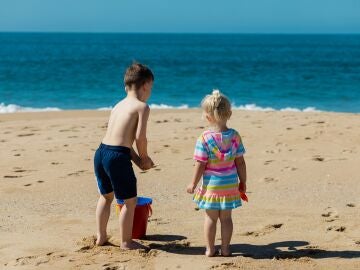 Un niño y una niña juegan en la arena de la playa