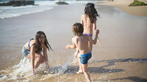 Grupo de niños y niñas jugando en la playa Grupo de niños y niñas jugando en la playa