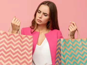 Mujer con bolsas de la compra y cara de duda Mujer con bolsas de la compra y cara de duda