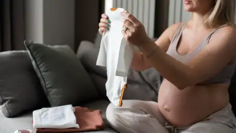 Una mujer embarazada prepara la bolsa del hospital Una mujer embarazada prepara la bolsa del hospital