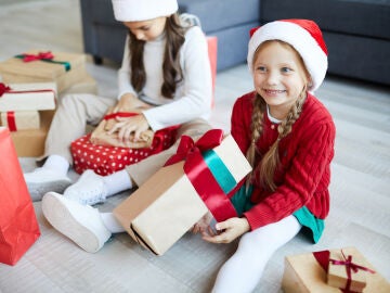 Niñas abriendo regalos en Navidad