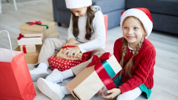 Niñas abriendo regalos en Navidad