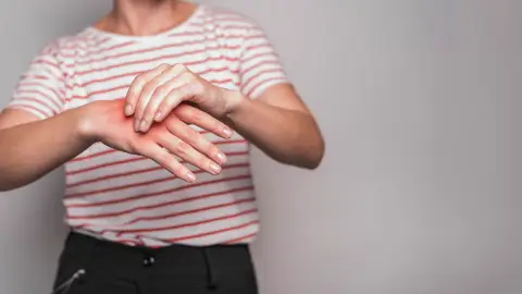 Una persona con dolor en las articulaciones de la mano Una persona con dolor en las articulaciones de la mano