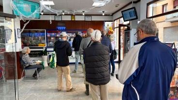 Varias personas guardan cola en una administraci&oacute;n de loter&iacute;a de Alfafar