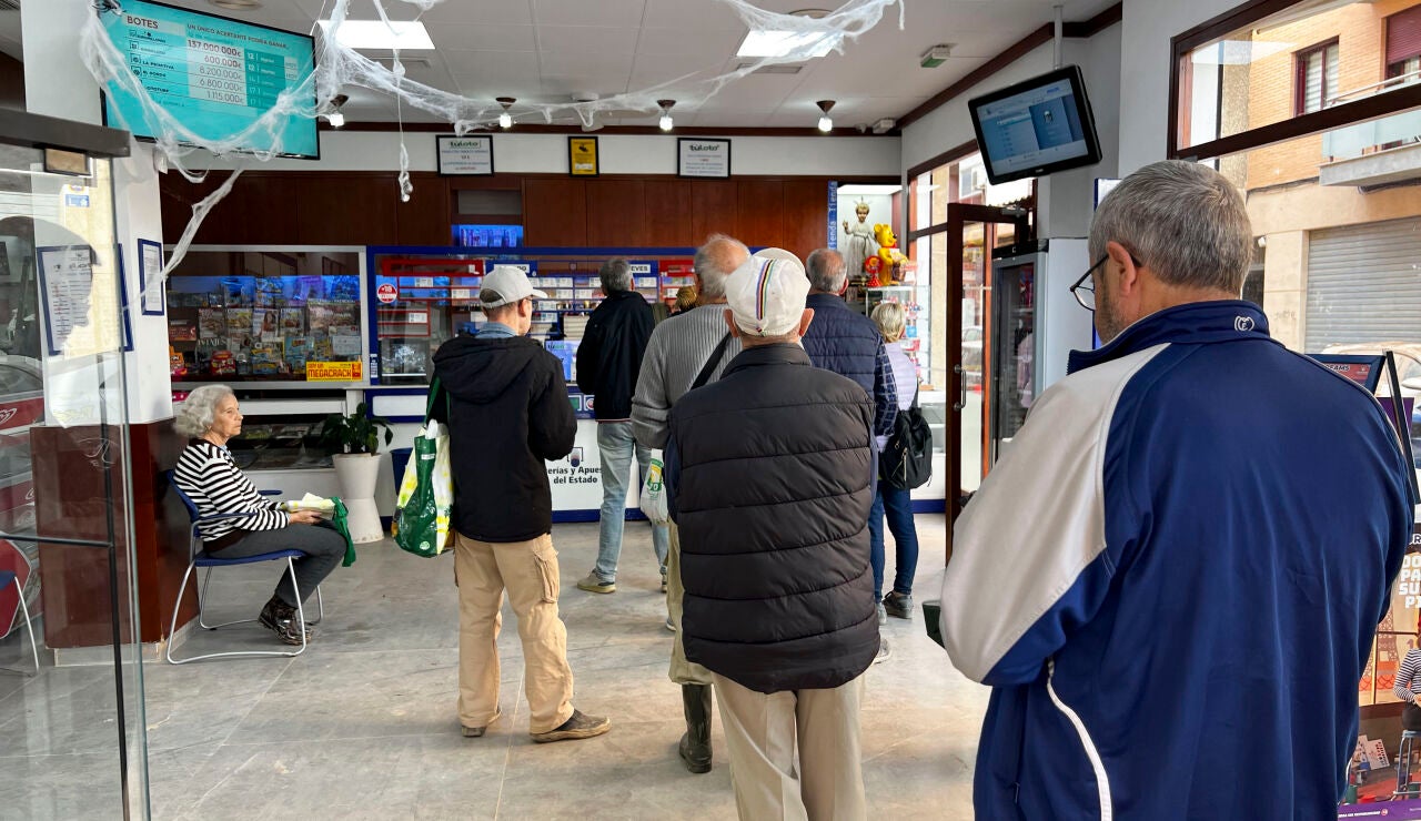 Varias personas guardan cola en una administraci&oacute;n de loter&iacute;a de Alfafar