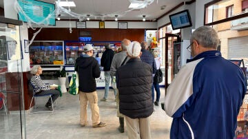 Varias personas guardan cola en una administración de lotería de Alfafar