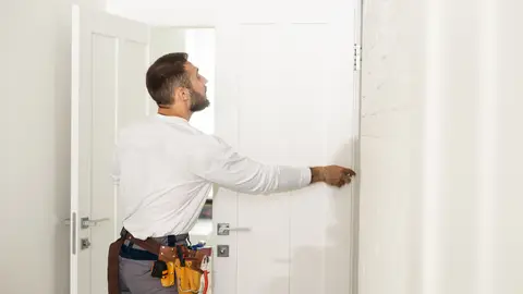 Hombre arreglando una puerta Hombre arreglando una puerta