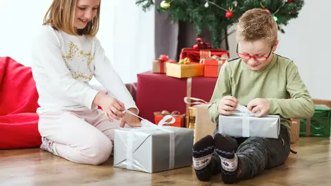 Niños en Navidad abriendo regalos Niños en Navidad abriendo regalos