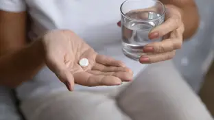 Una mujer tomando una aspirina Una mujer tomando una aspirina