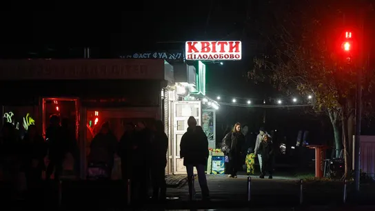 La gente camina en una zona residencial en la oscuridad durante un corte de energía programado en Kiev La gente camina en una zona residencial en la oscuridad durante un corte de energía programado en Kiev