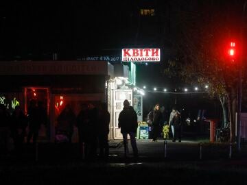 La gente camina en una zona residencial en la oscuridad durante un corte de energía programado en Kiev