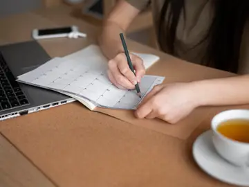 Una mujer planifica las tareas para aumentar la productividad Una mujer planifica las tareas para aumentar la productividad