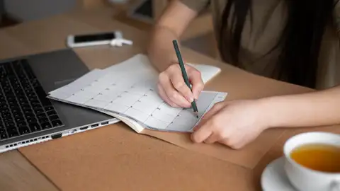 Una mujer planifica las tareas para aumentar la productividad Una mujer planifica las tareas para aumentar la productividad