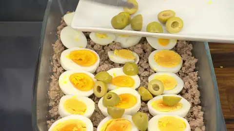 Corta los huevos en rodajas y las aceitunas por la mitad, y repártelos sobre la carne Corta los huevos en rodajas y las aceitunas por la mitad, y repártelos sobre la carne