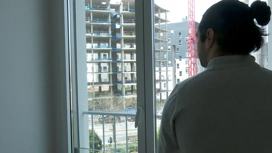Un joven contemplando la construcción de un bloque de pisos Un joven contemplando la construcción de un bloque de pisos