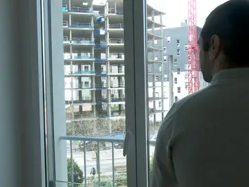 Un joven contemplando la construcción de un bloque de pisos Un joven contemplando la construcción de un bloque de pisos
