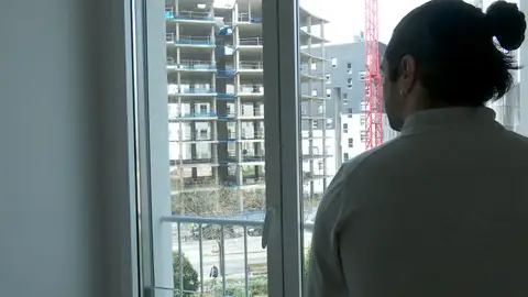 Un joven contemplando la construcción de un bloque de pisos Un joven contemplando la construcción de un bloque de pisos