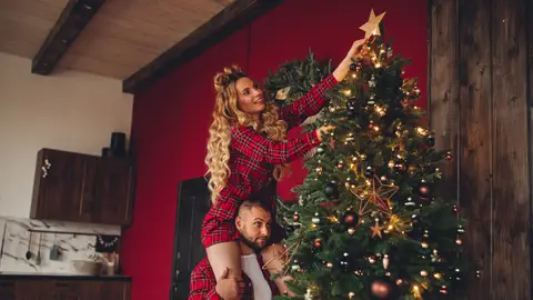Pareja colocando la estrella del árbol Pareja colocando la estrella del árbol
