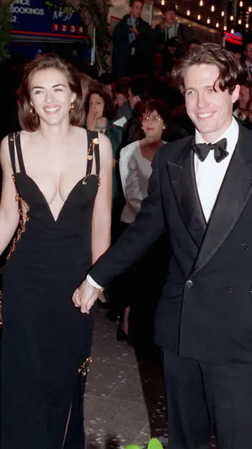 Elizabeth Hurley con su icónico vestido de Versace y Hugh Grant en estreno de Cuatro bodas y un funeral de 1994 Elizabeth Hurley con su icónico vestido de Versace y Hugh Grant en estreno de Cuatro bodas y un funeral de 1994