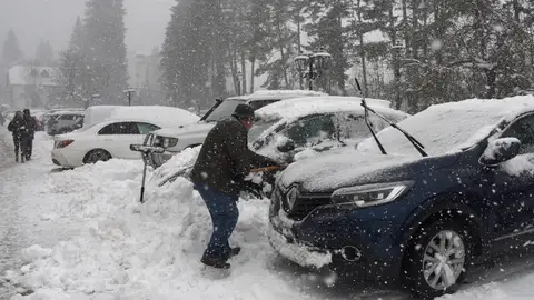 Turistas y habitantes de Canfranc quitan la nieve de sus coches con palas debido a la nieve caída. Turistas y habitantes de Canfranc quitan la nieve de sus coches con palas debido a la nieve caída.