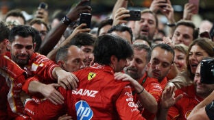 Carlos Sainz se abraza con los mec&aacute;nicos y miembros de Ferrari en Yas Marina