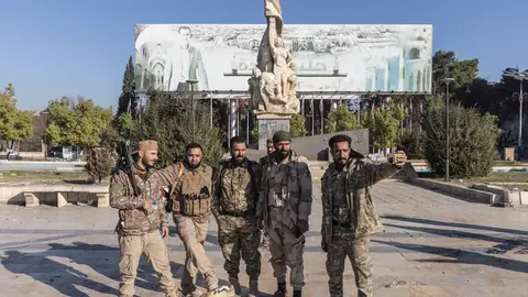 Miembros de grupos armados insurgentes posan tras el derribo de una estatua del expresidente Hafez al Assad Miembros de grupos armados insurgentes posan tras el derribo de una estatua del expresidente Hafez al Assad
