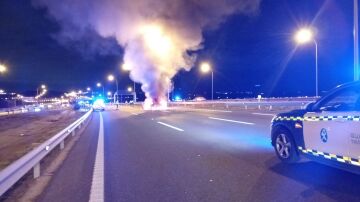 Vista de un coche en llamas al chocar contra otro vehículo en la M-45