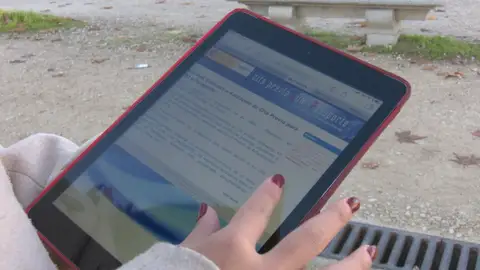 Una joven con una tablet intentando hacer una gestión Una joven con una tablet intentando hacer una gestión