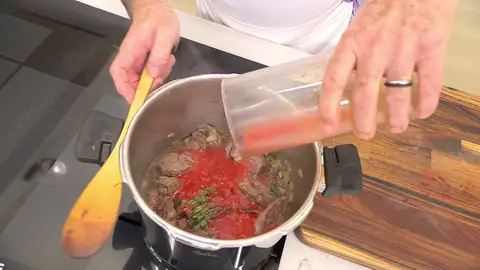 Agrega la mezcla al guiso y cúbrelo (a ras) con agua Agrega la mezcla al guiso y cúbrelo (a ras) con agua