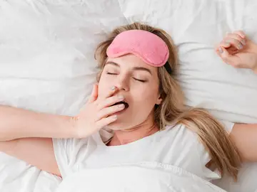 Mujer bostezando en la cama Mujer bostezando en la cama