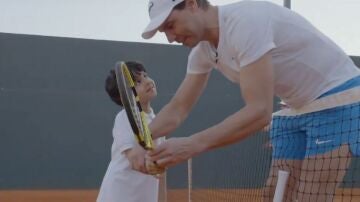 Rafa Nadal enseña a jugar al tenis a un niño