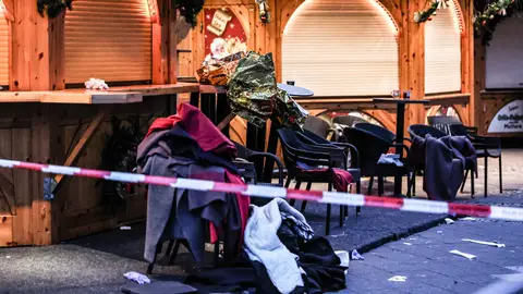 Prendas de ropa apiladas en sillas se ven detrás de un cordón policial después de un atropello en un mercadillo de Navidad en Magdeburgo Prendas de ropa apiladas en sillas se ven detrás de un cordón policial después de un atropello en un mercadillo de Navidad en Magdeburgo