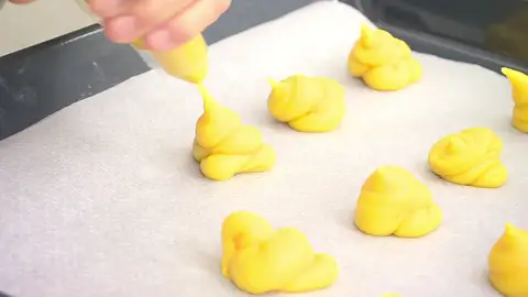 Cubre una bandeja de horno con un papel sulfurizado y forma 18 montoncitos Cubre una bandeja de horno con un papel sulfurizado y forma 18 montoncitos