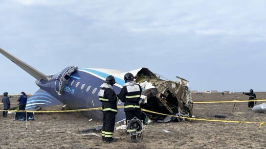 Miembros de los servicios de emergencias examinan los restos del avi&oacute;n 