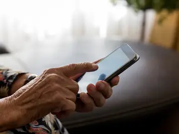 Un jubilado con su teléfono móvil Un jubilado con su teléfono móvil