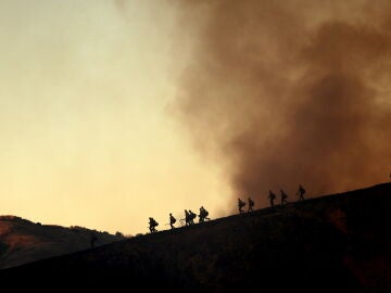 Los bomberos toman posiciones para combatir el incendio Kenneth en el vecindario de Woodland Hills en Los Ángeles, California