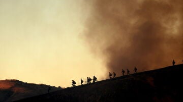 Los bomberos toman posiciones para combatir el incendio Kenneth en el vecindario de Woodland Hills en Los Ángeles, California