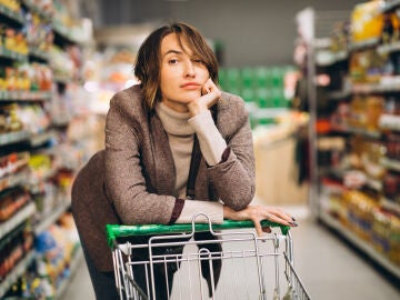 Una mujer disgustada en el s&uacute;per con el carro de la compra