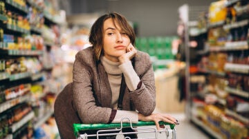 Una mujer disgustada en el súper con el carro de la compra