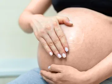 Mujer embarazada con crema en la barriga Mujer embarazada con crema en la barriga