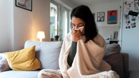 Mujer con tos y mocos por un resfriado Mujer con tos y mocos por un resfriado