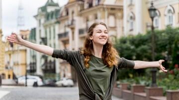 Una mujer feliz pasea en la ciudad